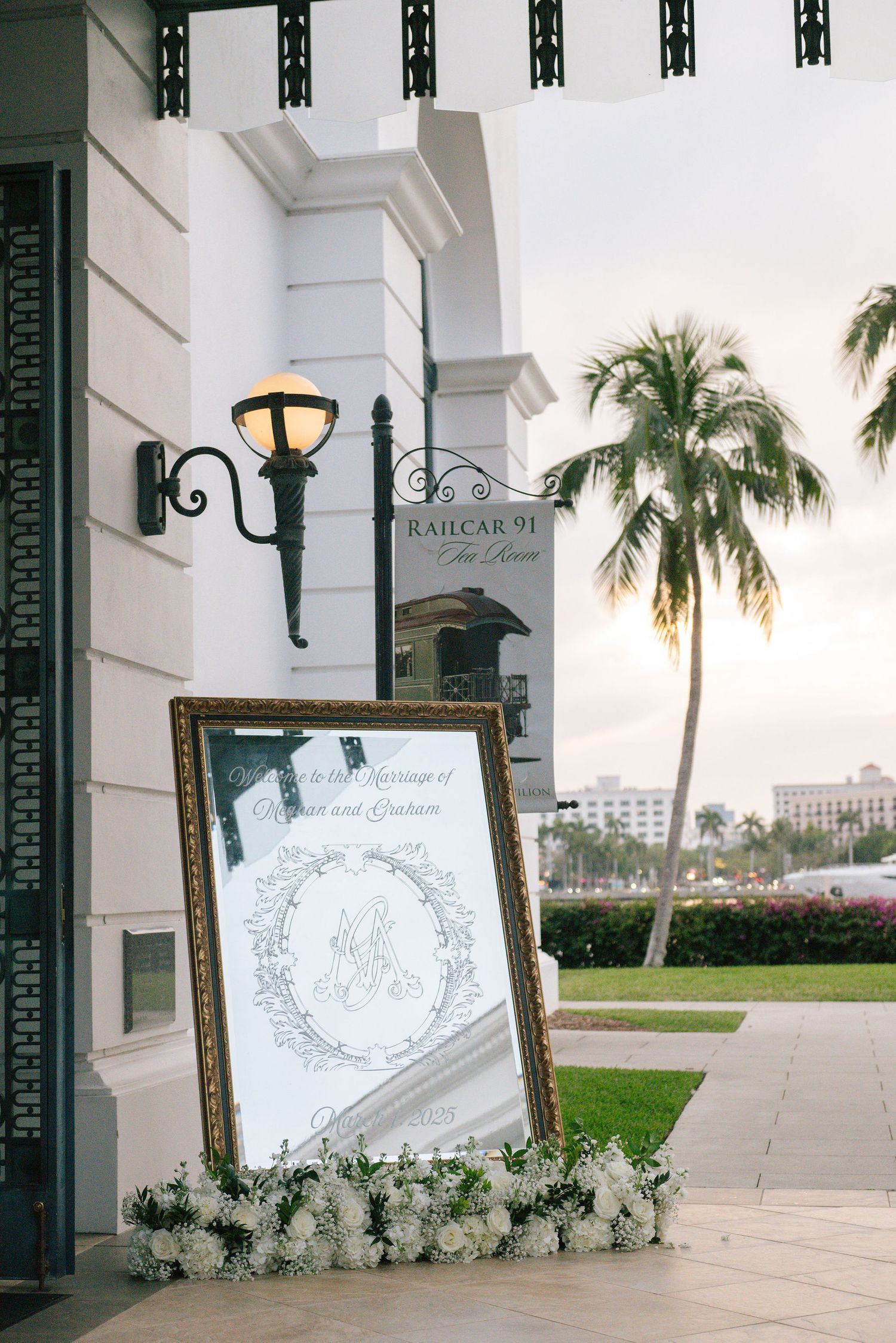 Elegant wedding seating charts displayed on white easels with floral arrangements.