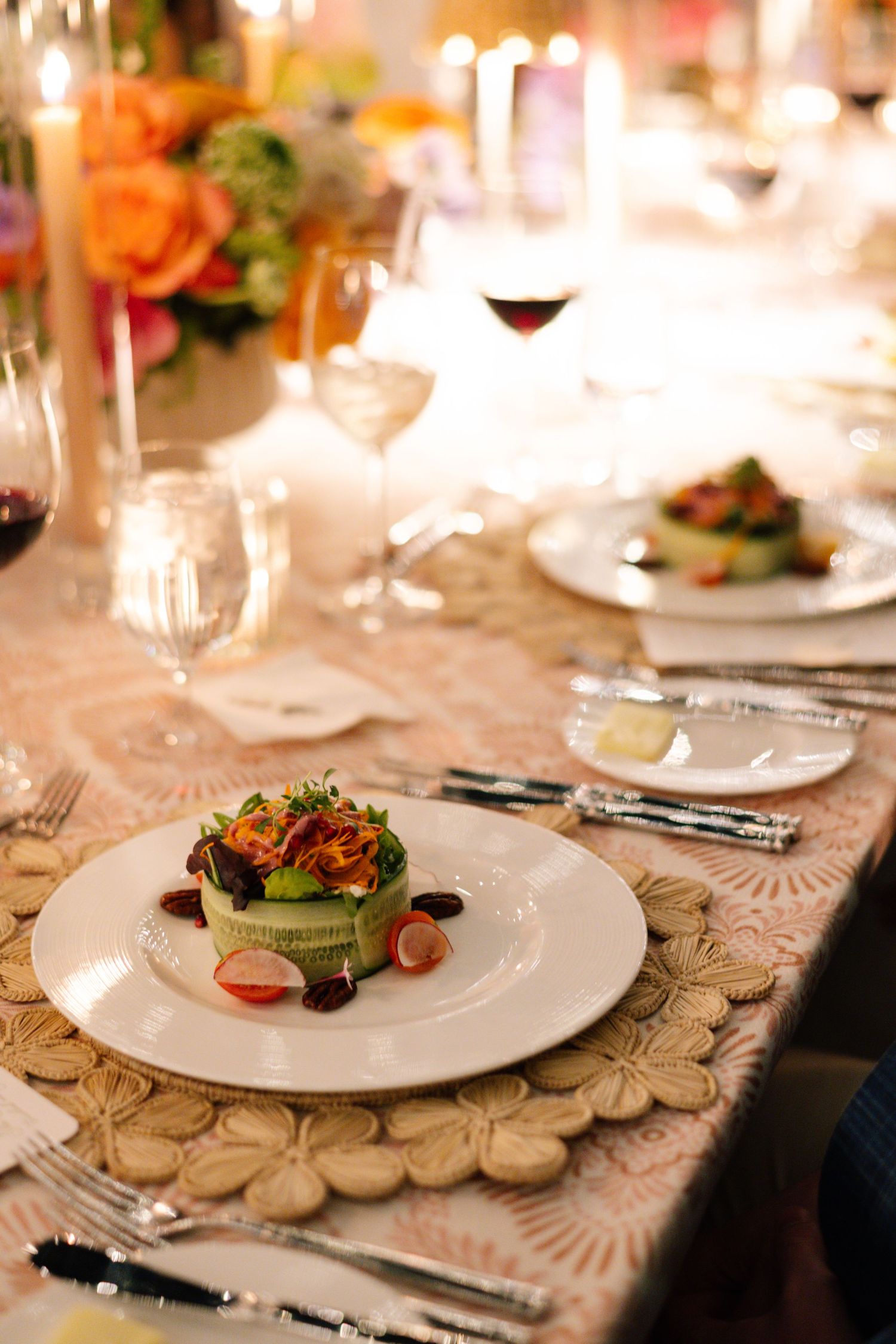 Elegant place settings with white plates and floral centerpieces on textured placemats.