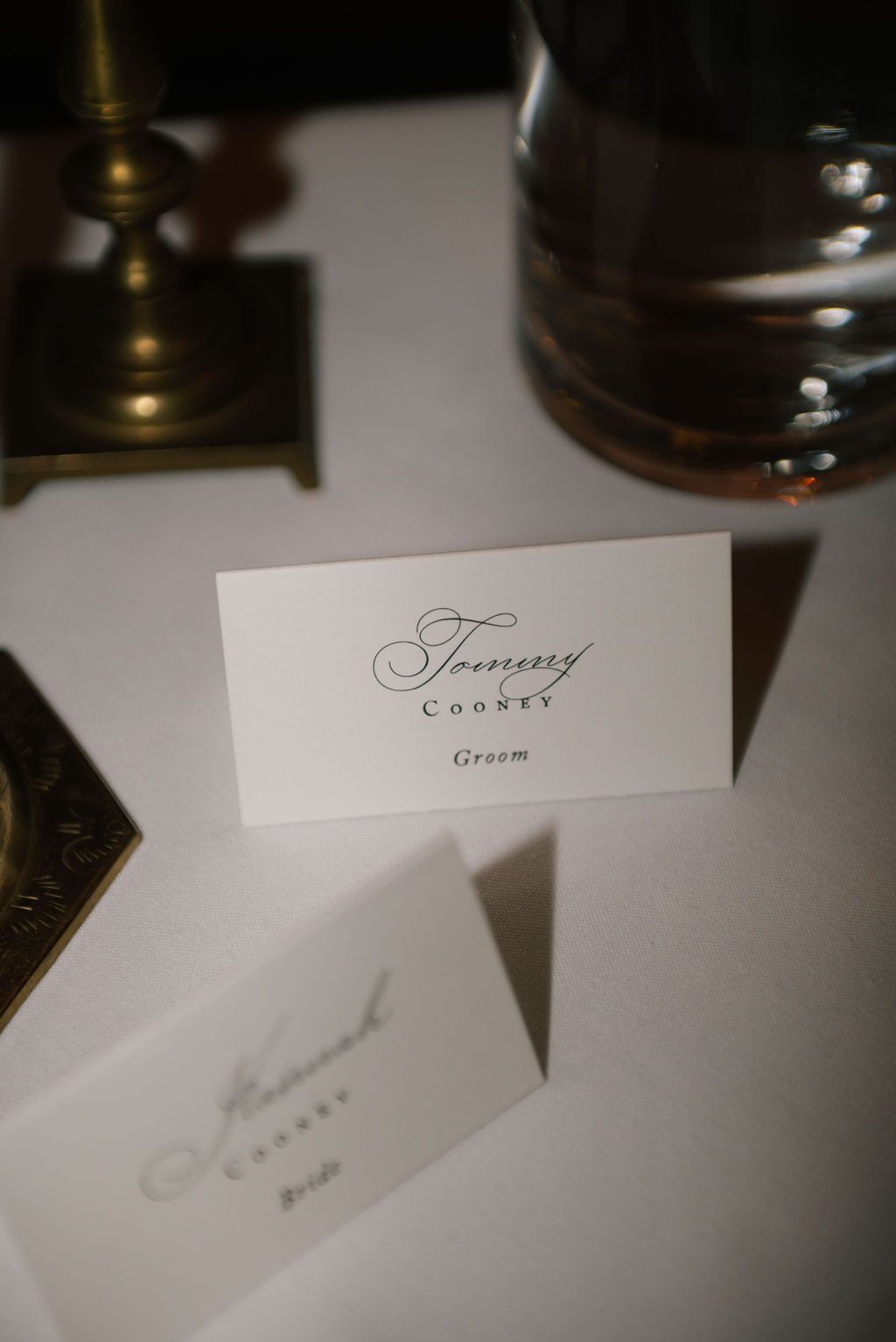 Elegant white place cards with calligraphy names displayed at formal table settings.