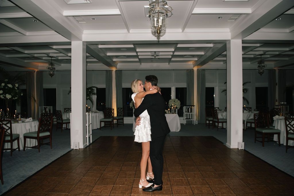 Large empty reception venue with white columns and coffered ceiling.