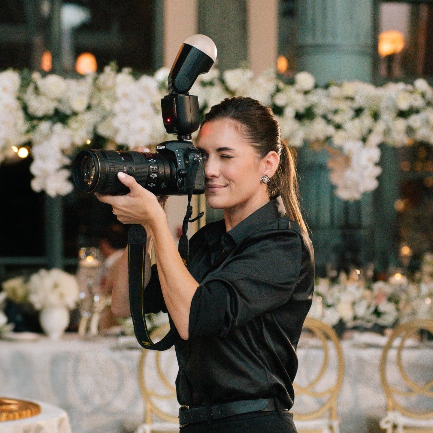 Wedding photographers in black attire capture moments at an elegant reception.