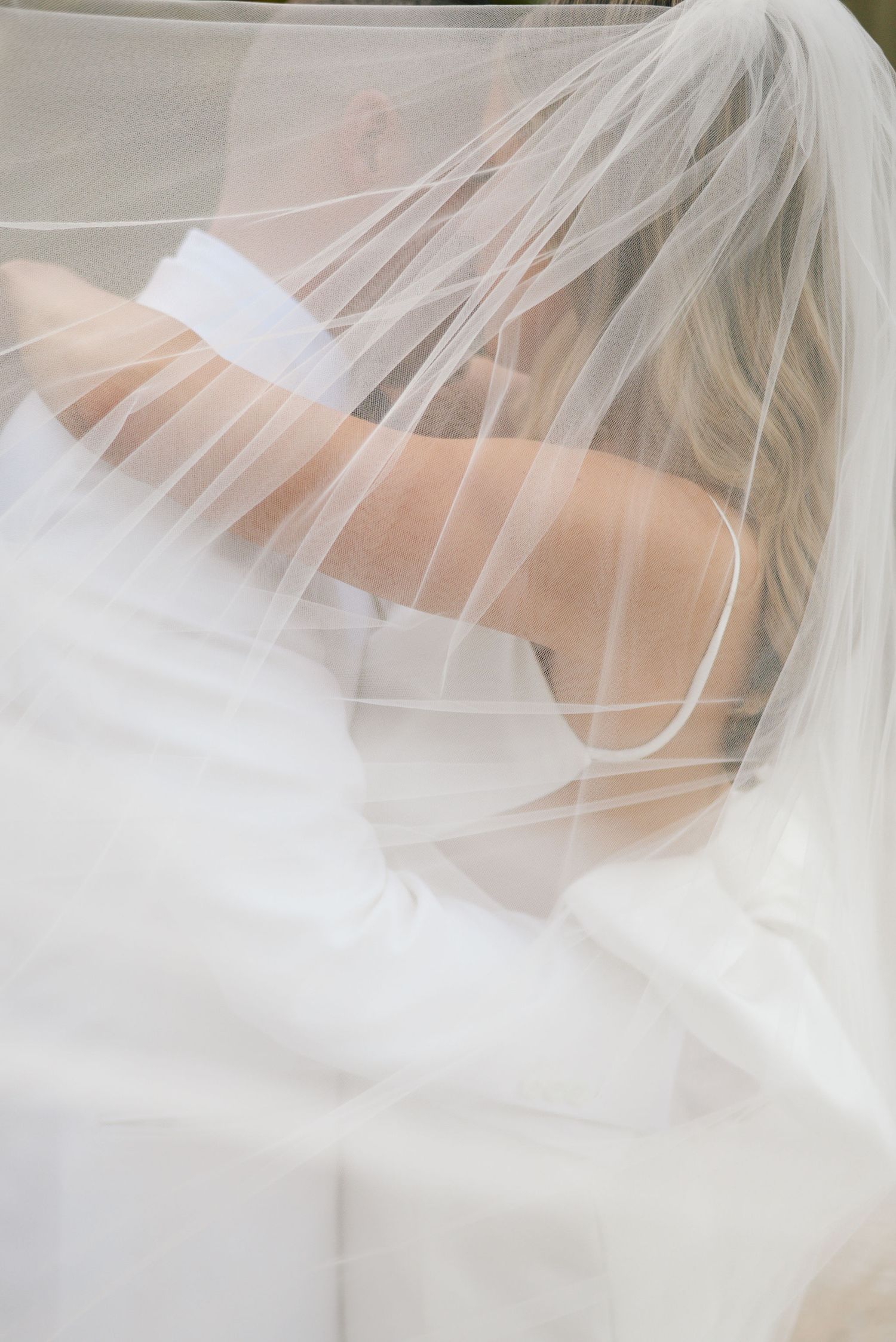 Close-up details of delicate white wedding veil fabric creating ethereal textures and patterns.