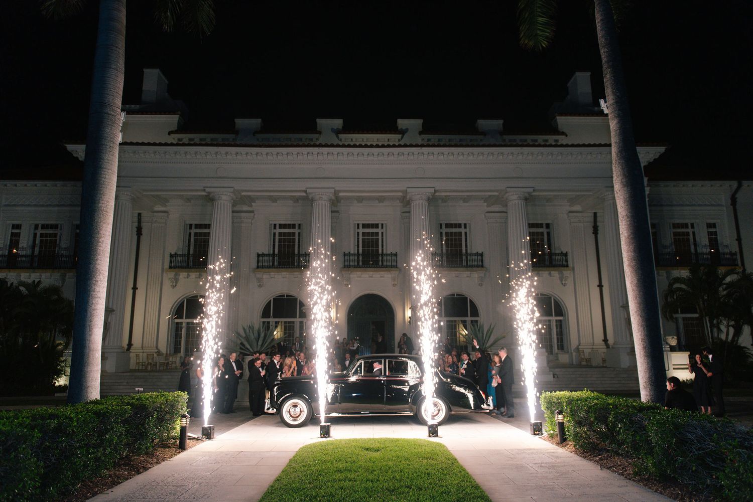 Nighttime view of an elegant building facade illuminated with spotlights.