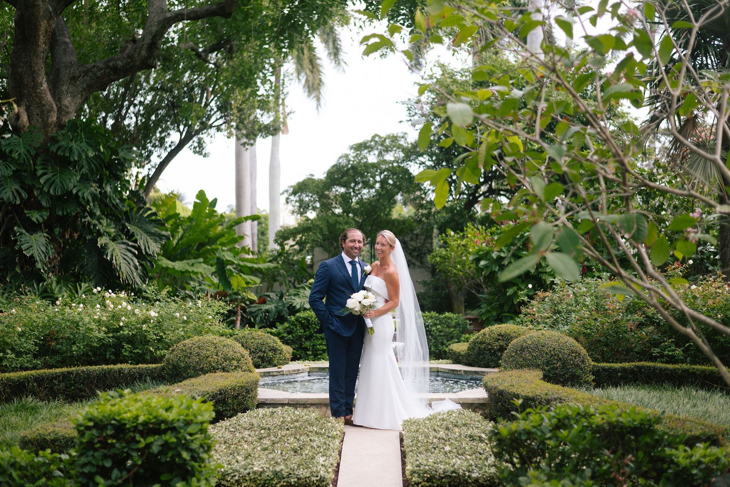 Elegant garden wedding venue with manicured hedges and natural landscaping.
