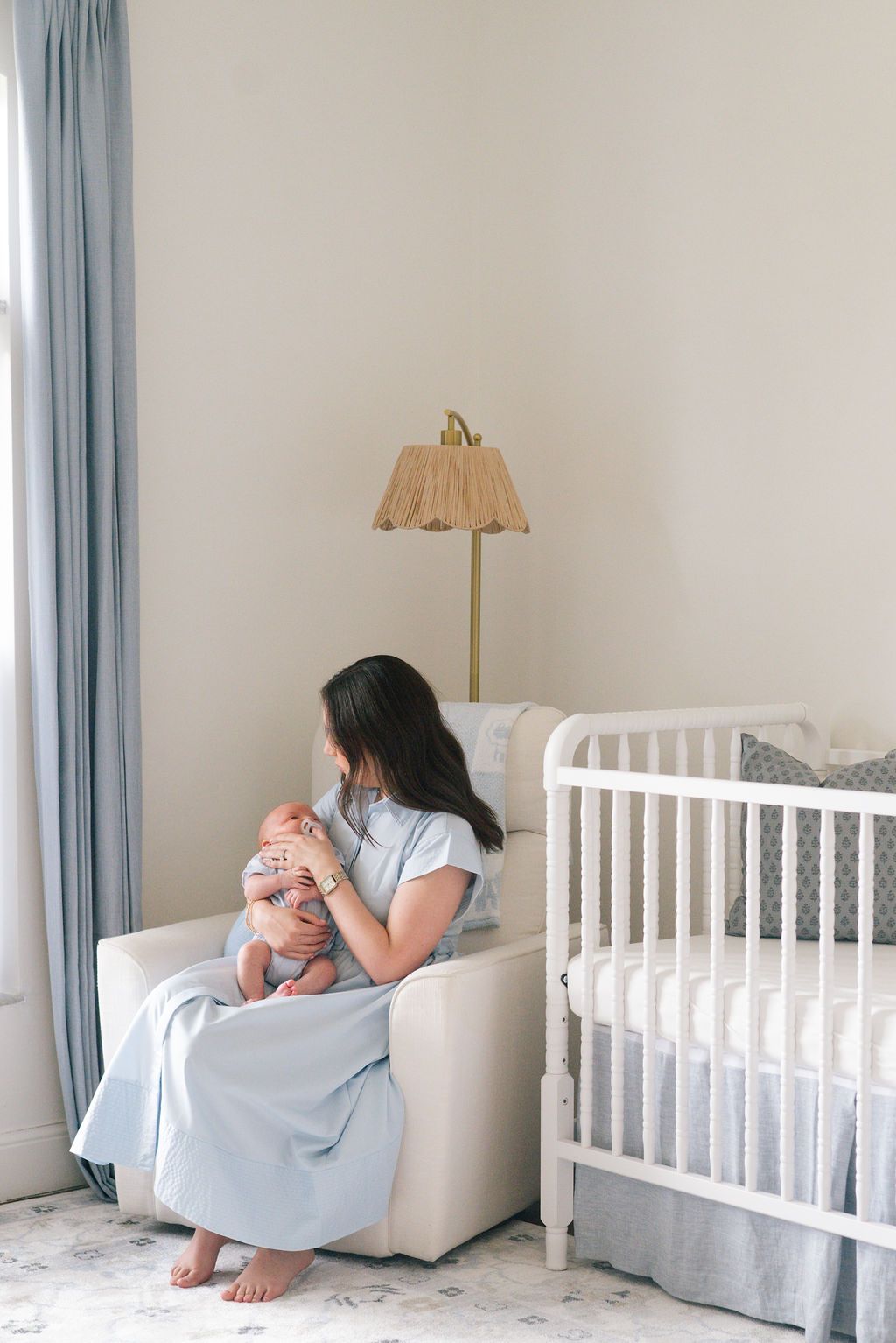 Cozy nursery interior with white crib and soft blue accents.