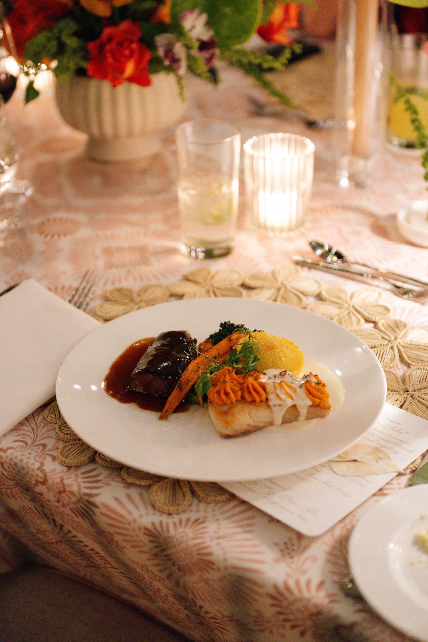 Elegant plated dinner course served on white china with decorative lace tablecloth.