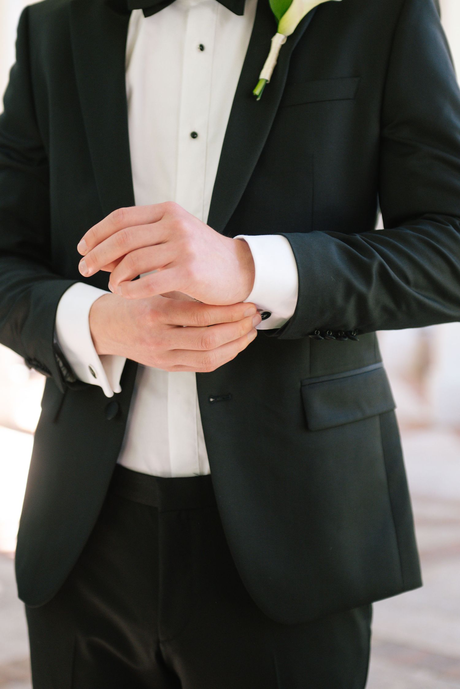 Close-up details of formal black tuxedo with white shirt and cufflinks.