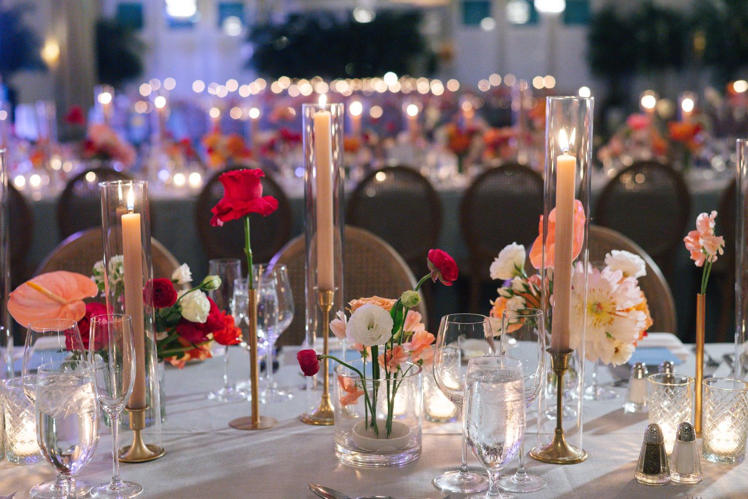 Romantic reception table setting with candlesticks and floral centerpieces.