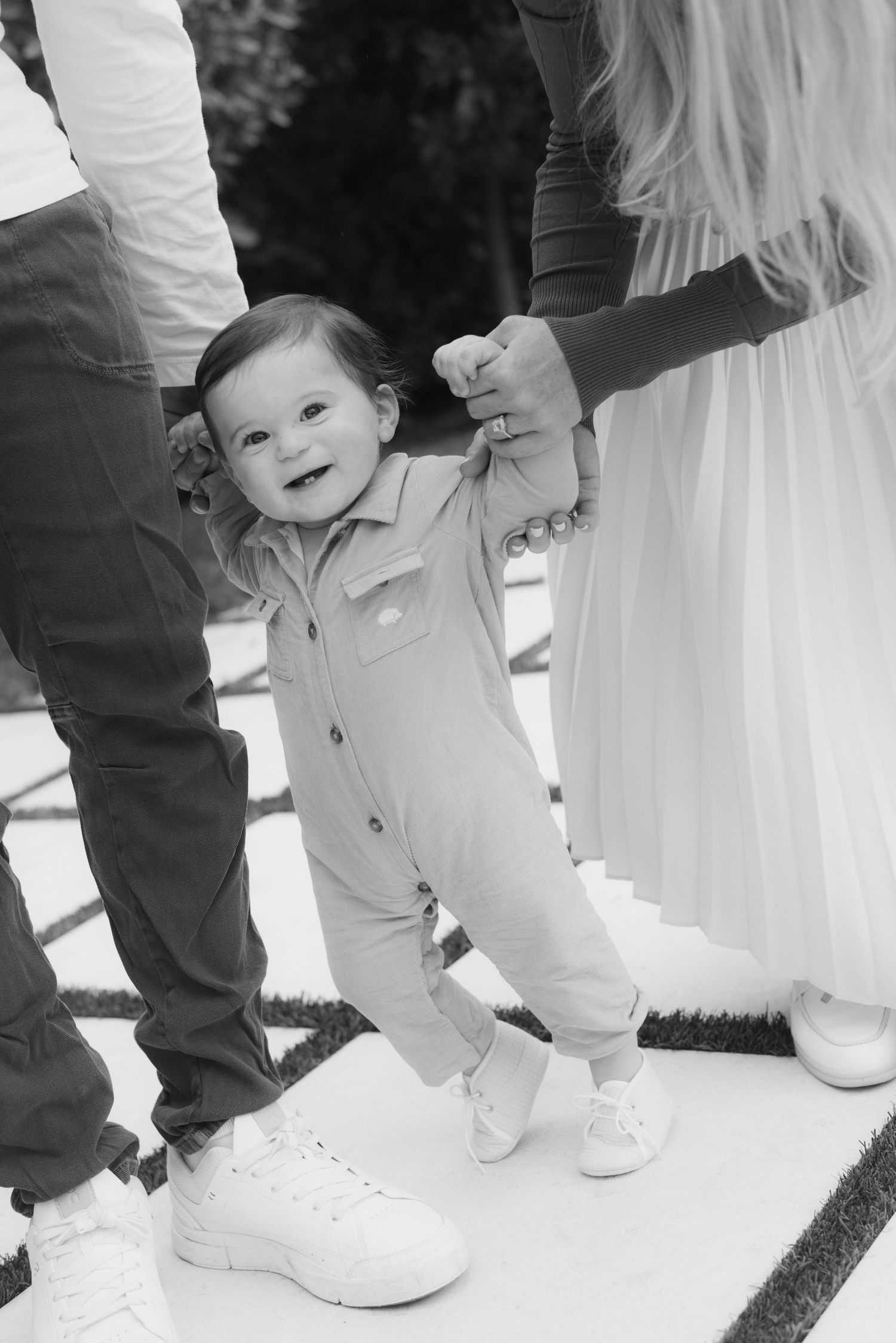 Series of black and white photos showing small feet in white sneakers standing next to formal dress attire.