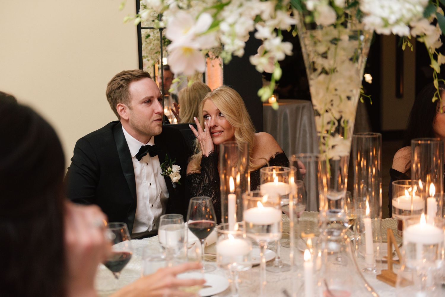 Romantic candlelit reception dinner with glowing centerpieces and floral arrangements on elegant tables.