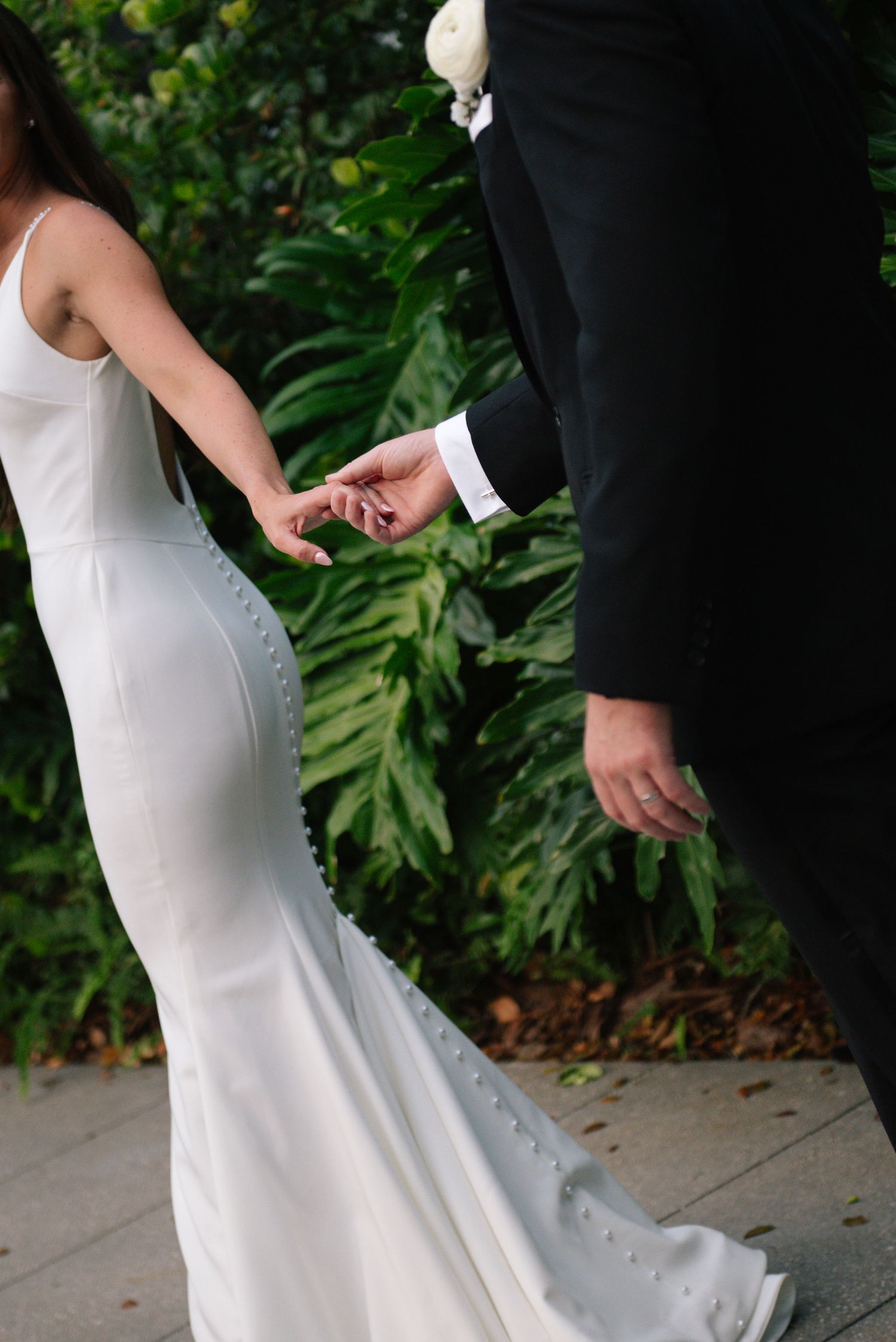 A sequence of photos showing the details of a white wedding dress against lush green foliage.