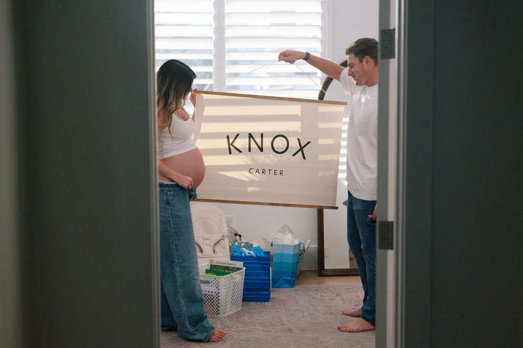 Cardboard boxes being arranged in a bright room with white shutters.