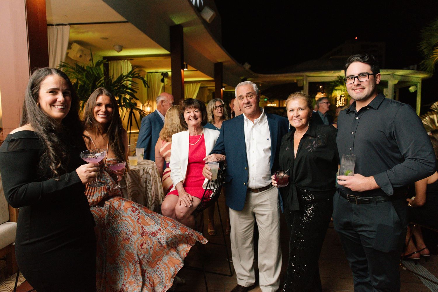 Group of party guests gathered indoors for a social event.