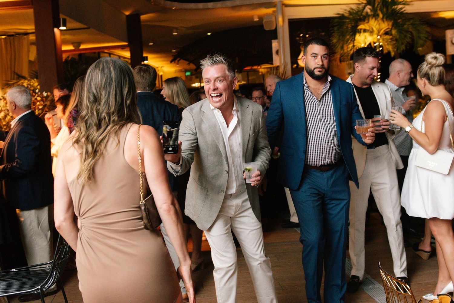 Wedding reception guests dancing and celebrating on a lively dance floor.