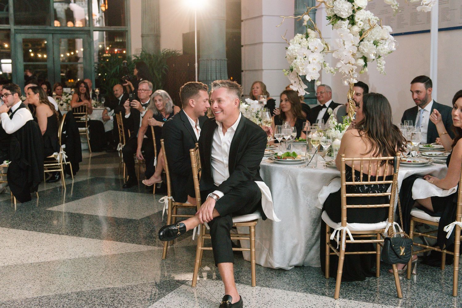 Newlywed couple sharing intimate moment at decorated wedding reception dinner table.