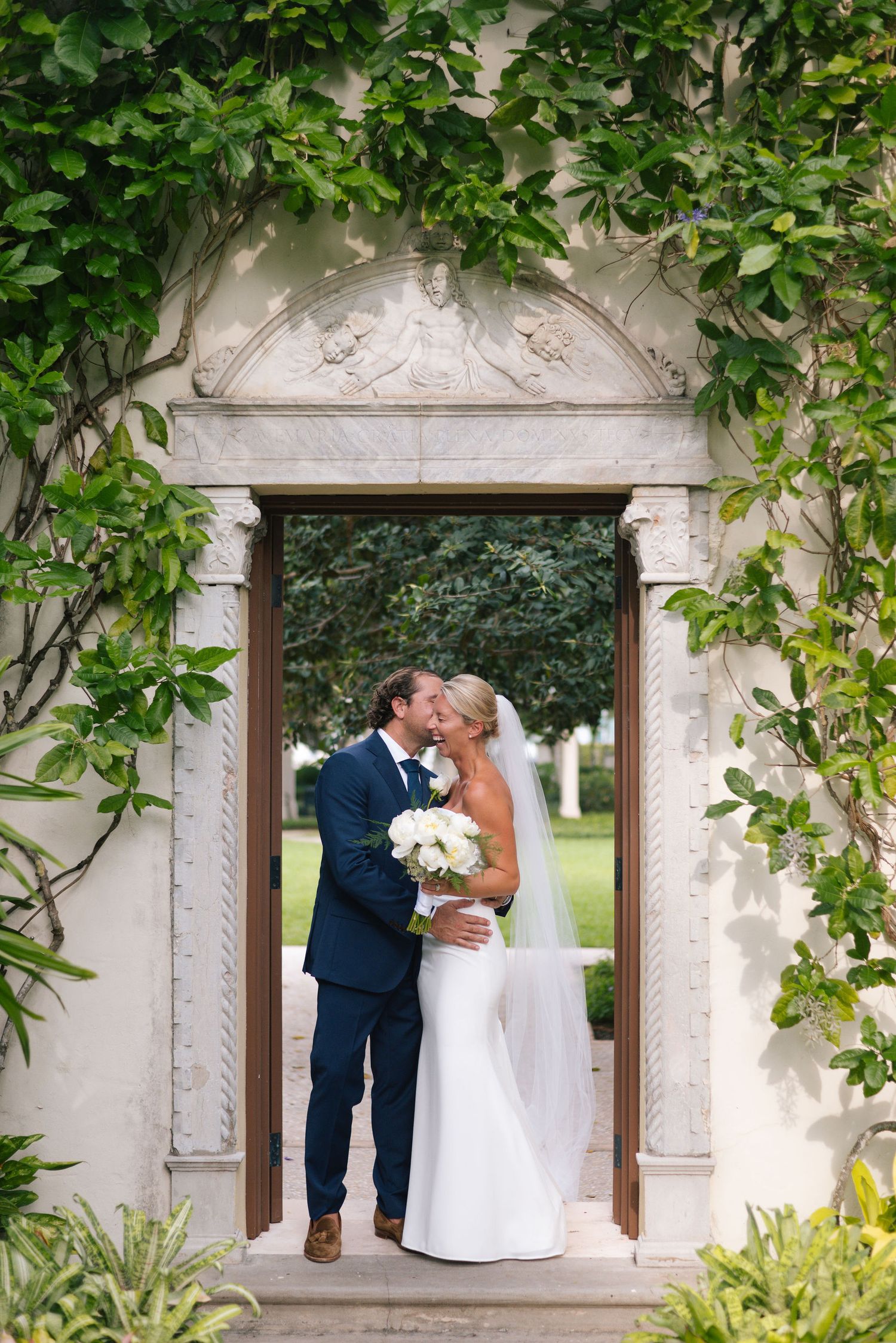 Romantic garden archway framed with lush green vines at a wedding venue.