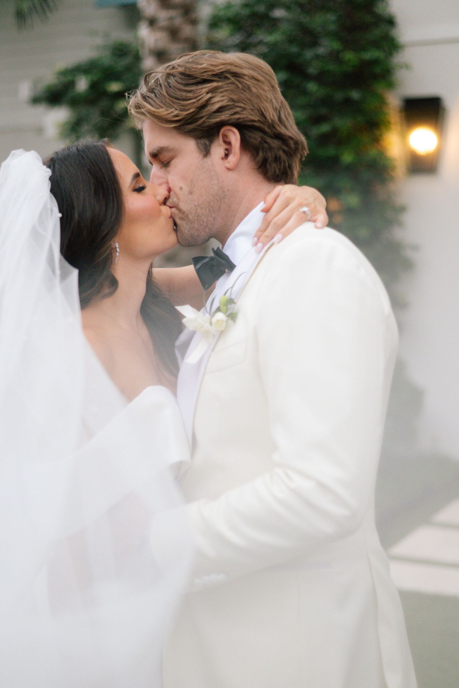 A romantic wedding portrait with soft lighting and elegant white attire.
