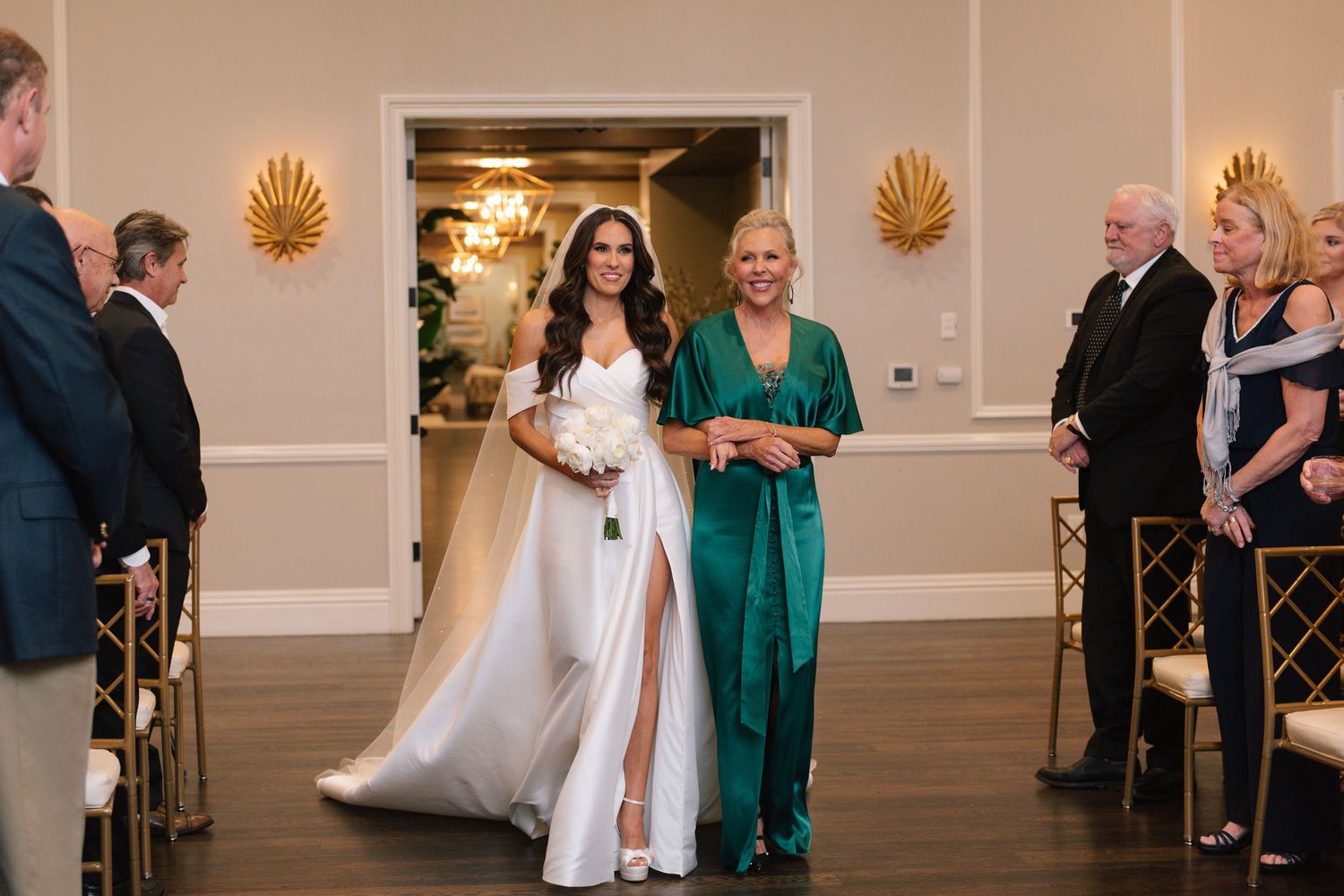 Wedding ceremony in progress inside an elegant ballroom with decorative shell accents.