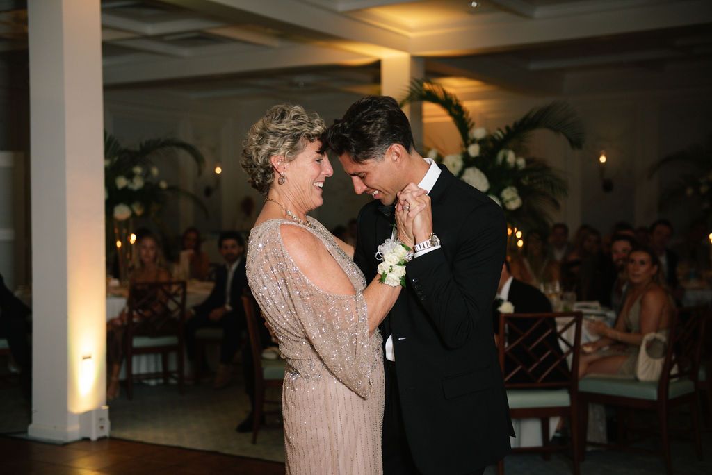 Mother-son dance captured during an elegant evening wedding reception.