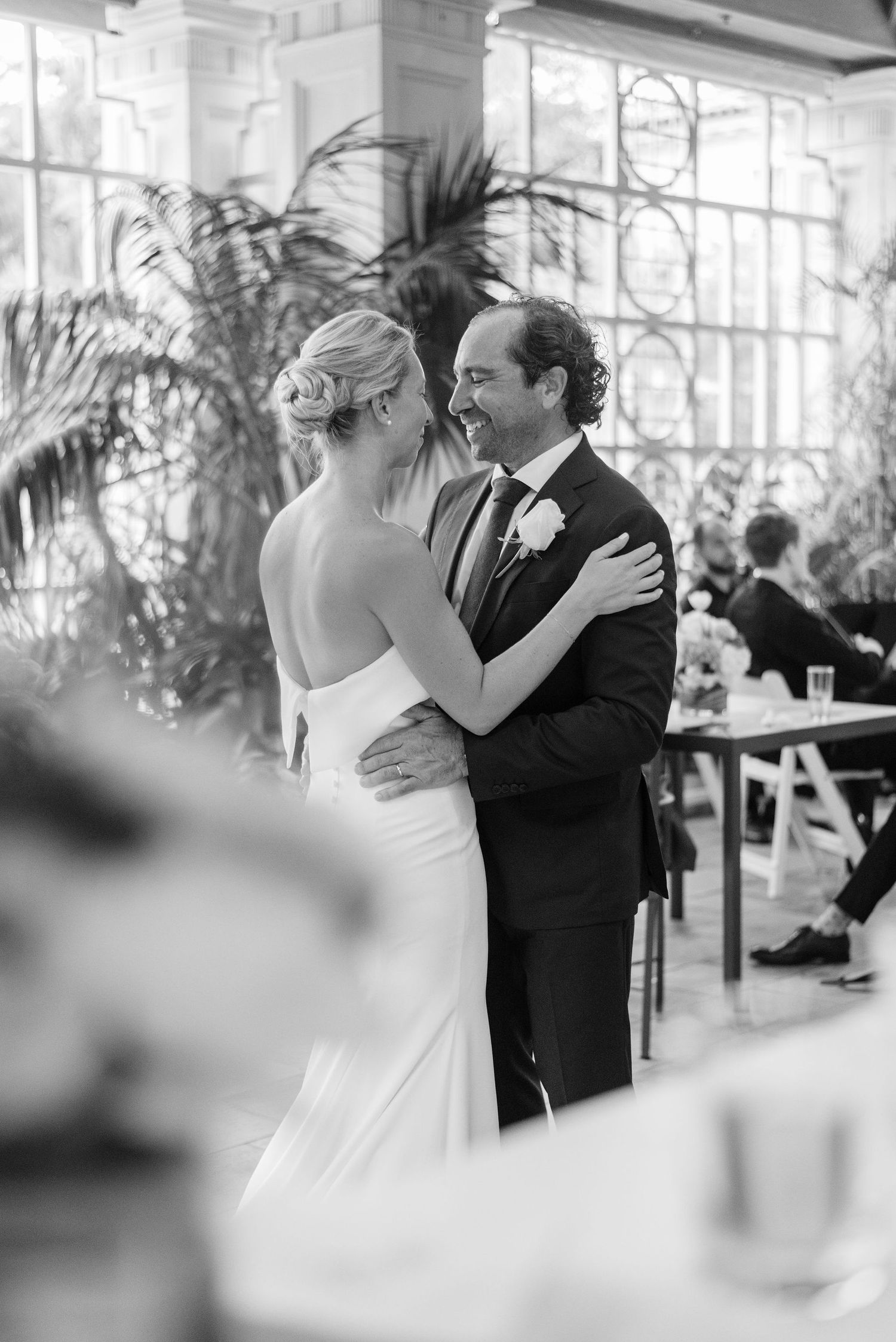 Black and white photo of a romantic dance moment in a glass-enclosed venue.