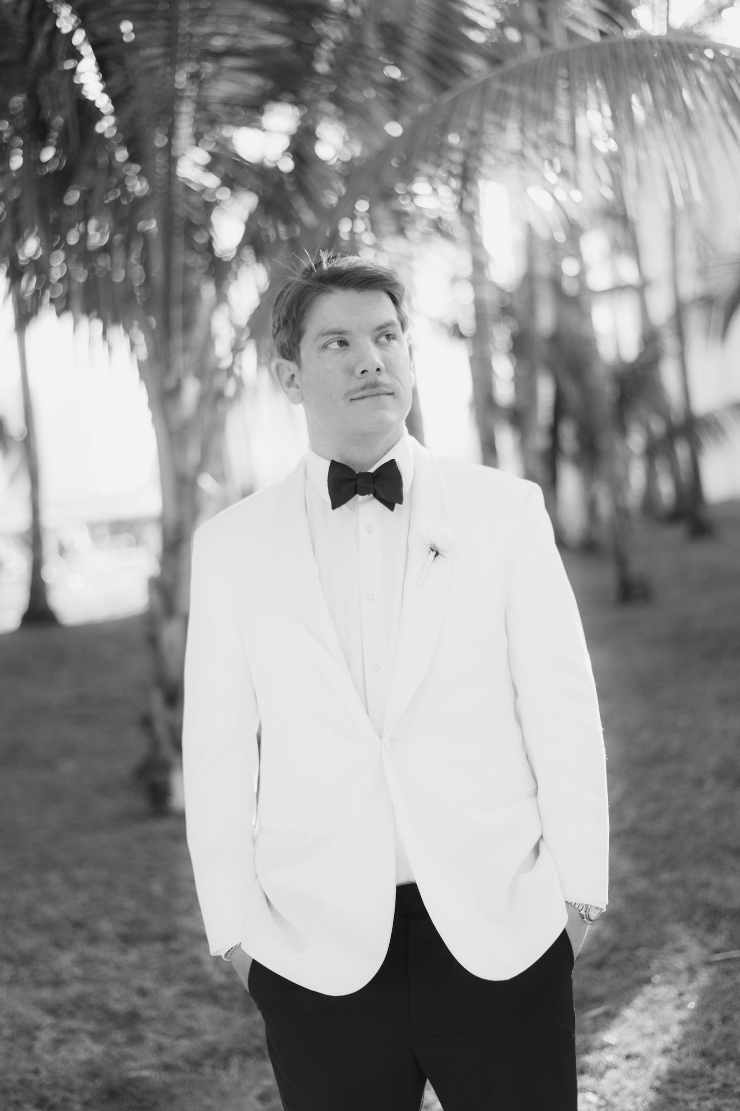 A formal portrait session in a tropical garden setting with white columns.