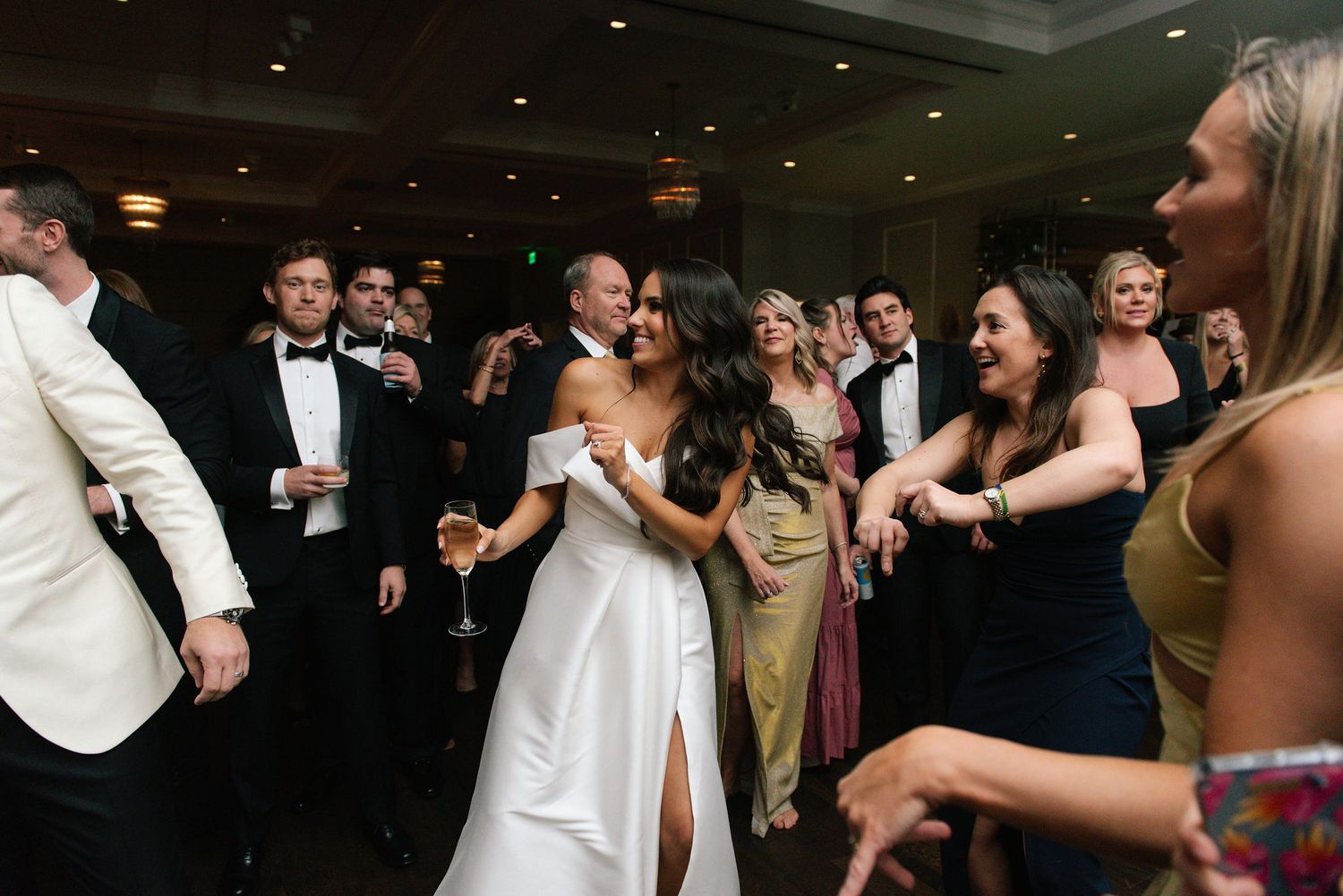 Wedding party dancing together during a lively reception celebration.