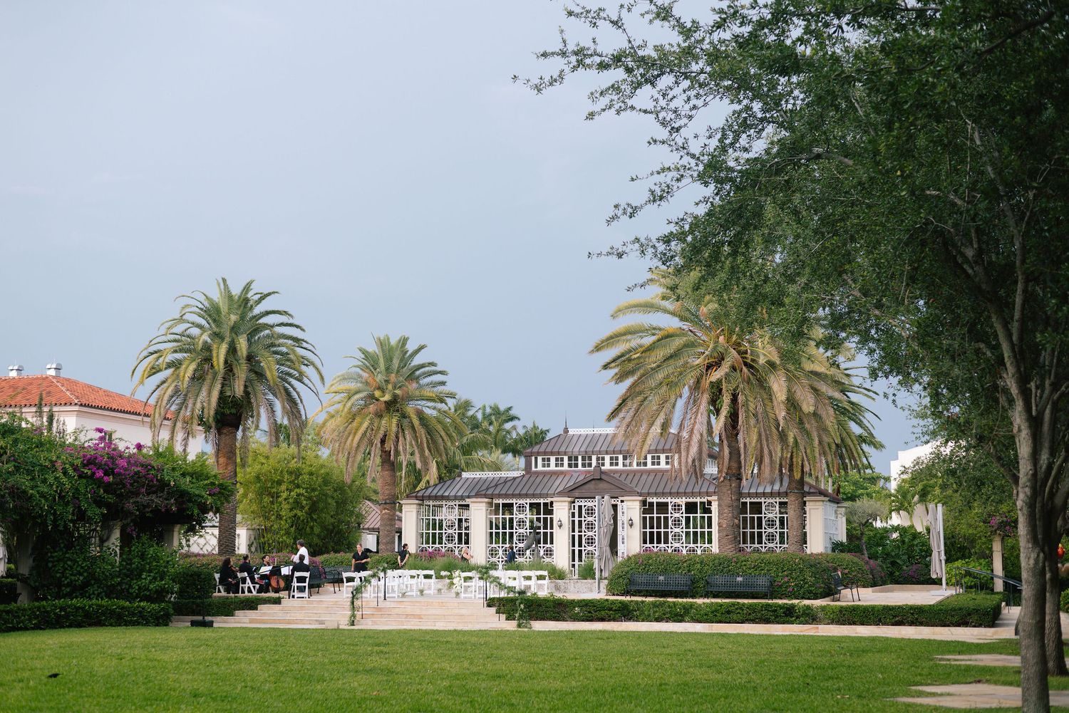 Panoramic view of a stately mansion with palm trees and manicured grounds for a wedding venue.