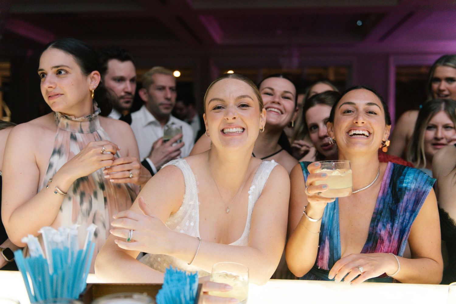 Joyful wedding party celebrating and dancing together at an evening reception.