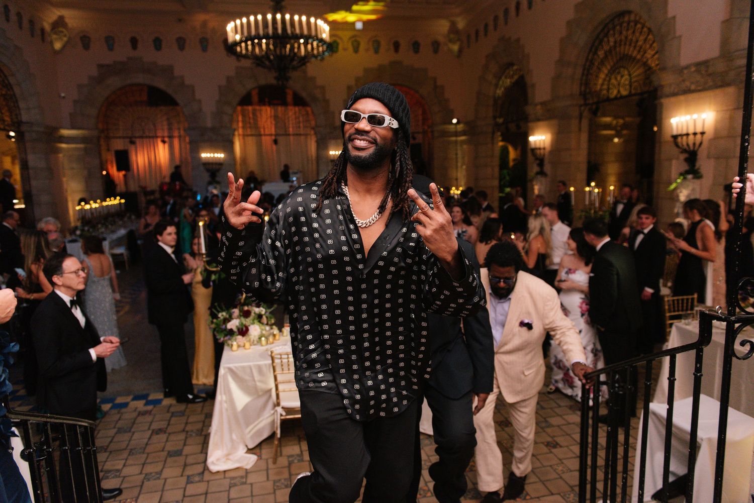Guests in black-tie attire enjoying entertainment at an elegant ballroom reception.
