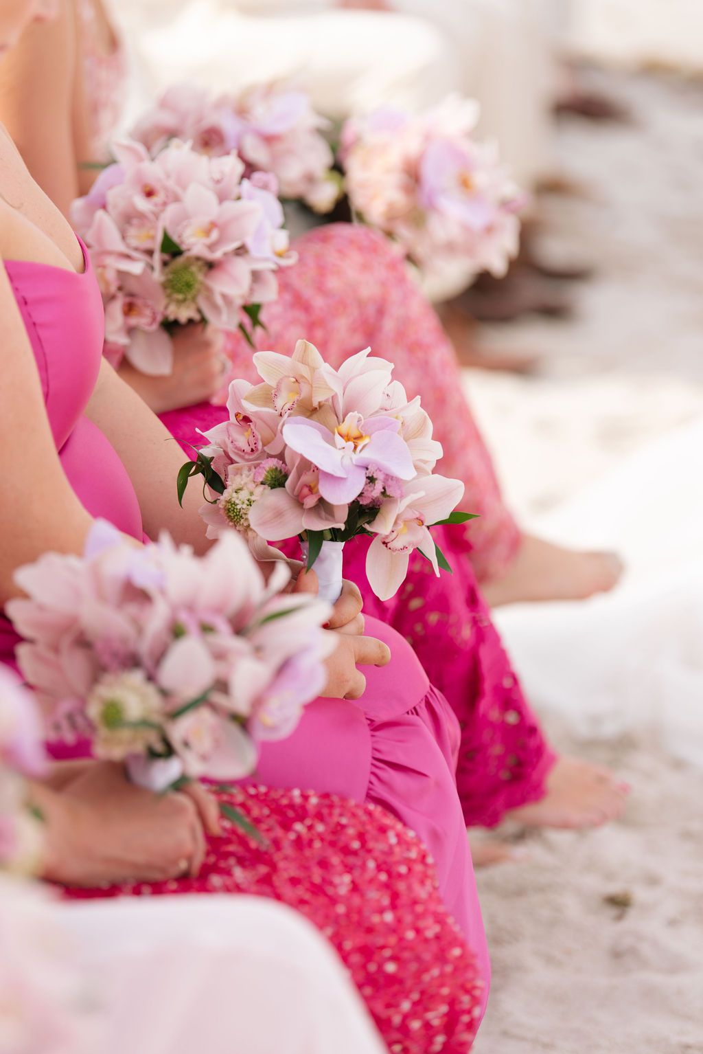 Pink floral bouquets and details from a beach wedding ceremony.