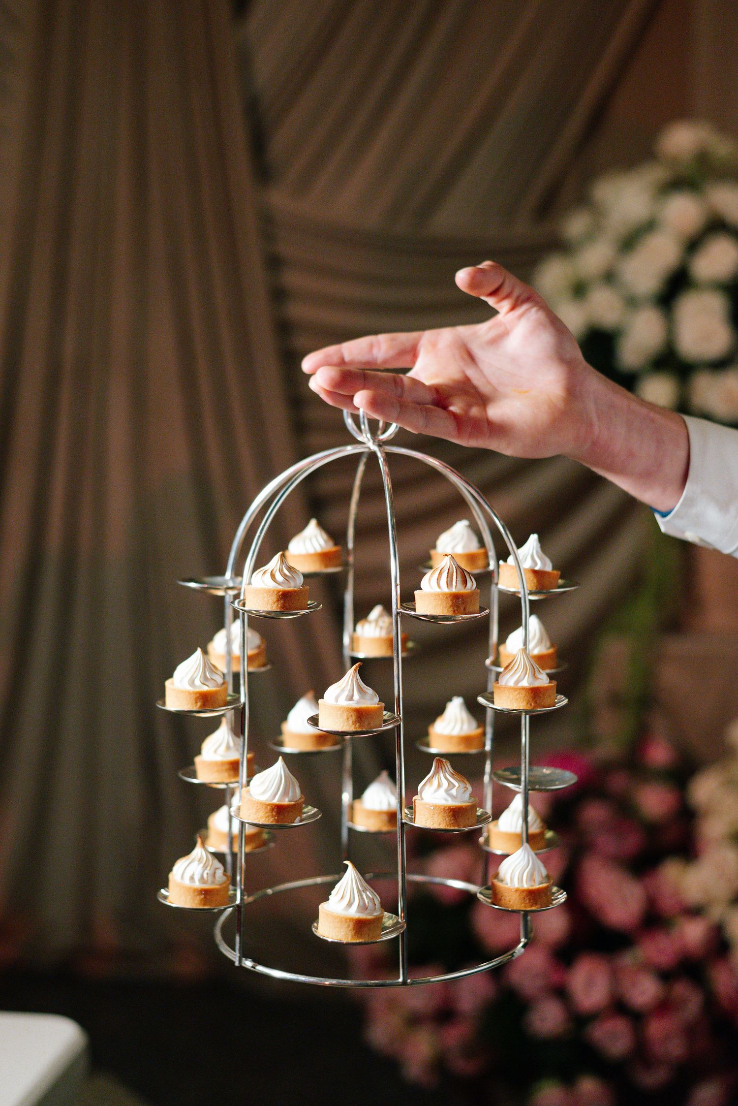 Elegant tiered dessert display with mini pastries on silver stands.