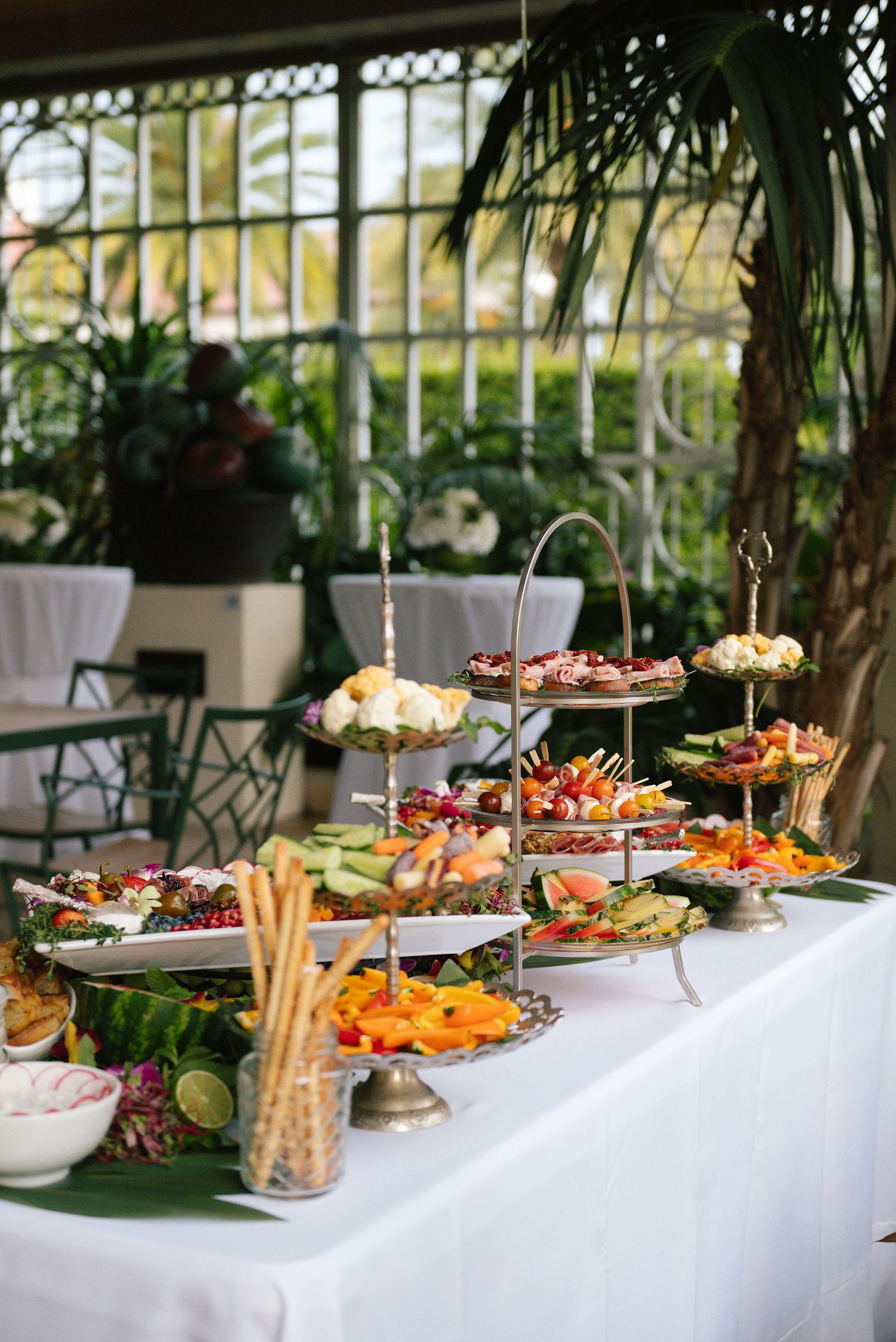 Elegant buffet table with diverse appetizers and hors d'oeuvres displayed on tiered platters.
