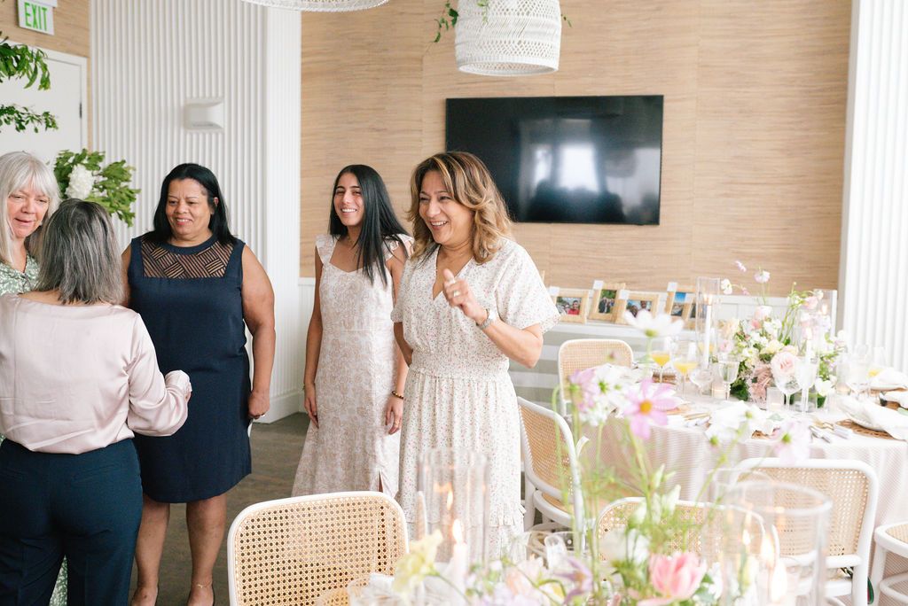 Elegant table settings with pink floral arrangements and rattan chairs at a special event brunch.
