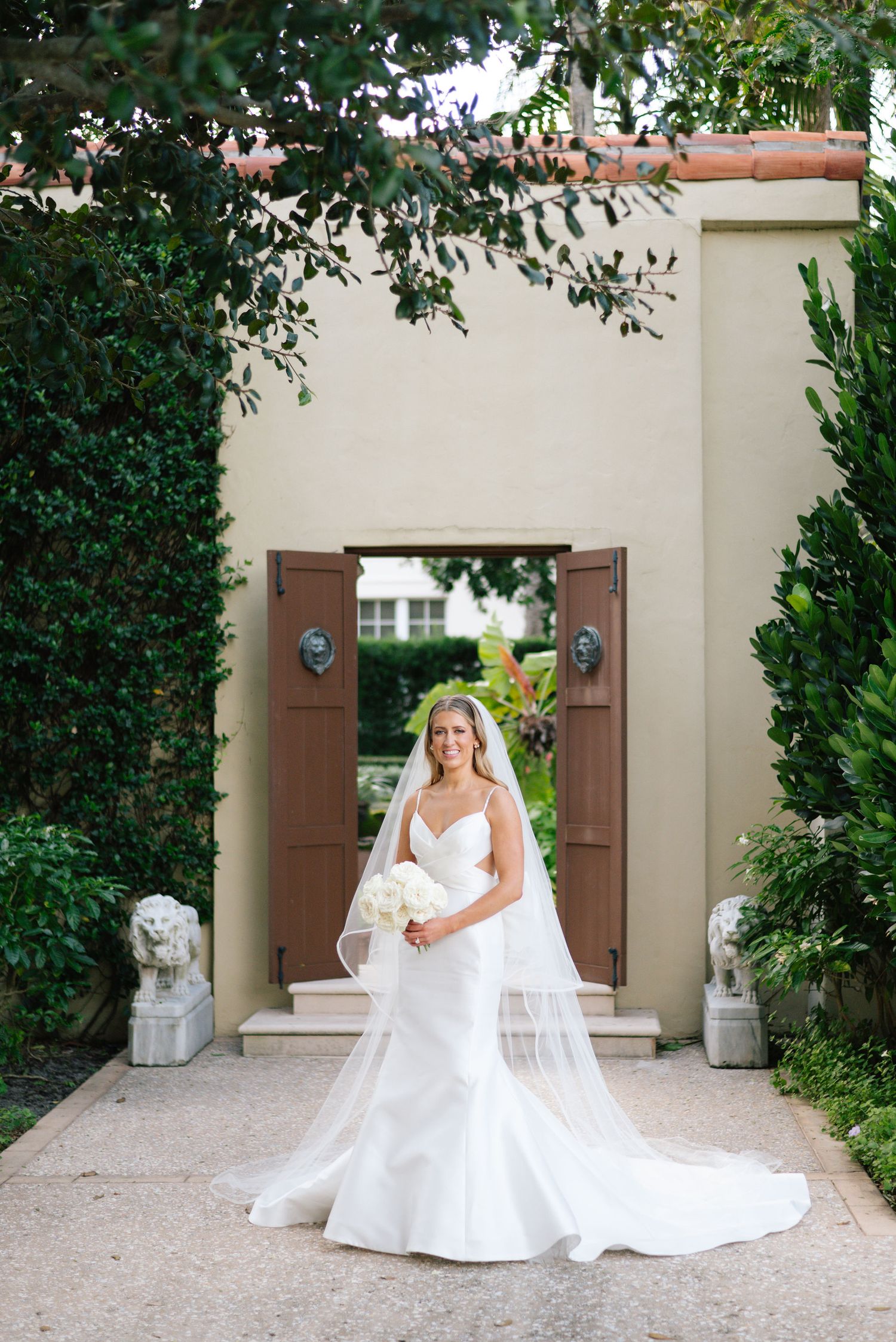 A bridal photoshoot sequence in a garden courtyard with brown shutters and lush greenery.