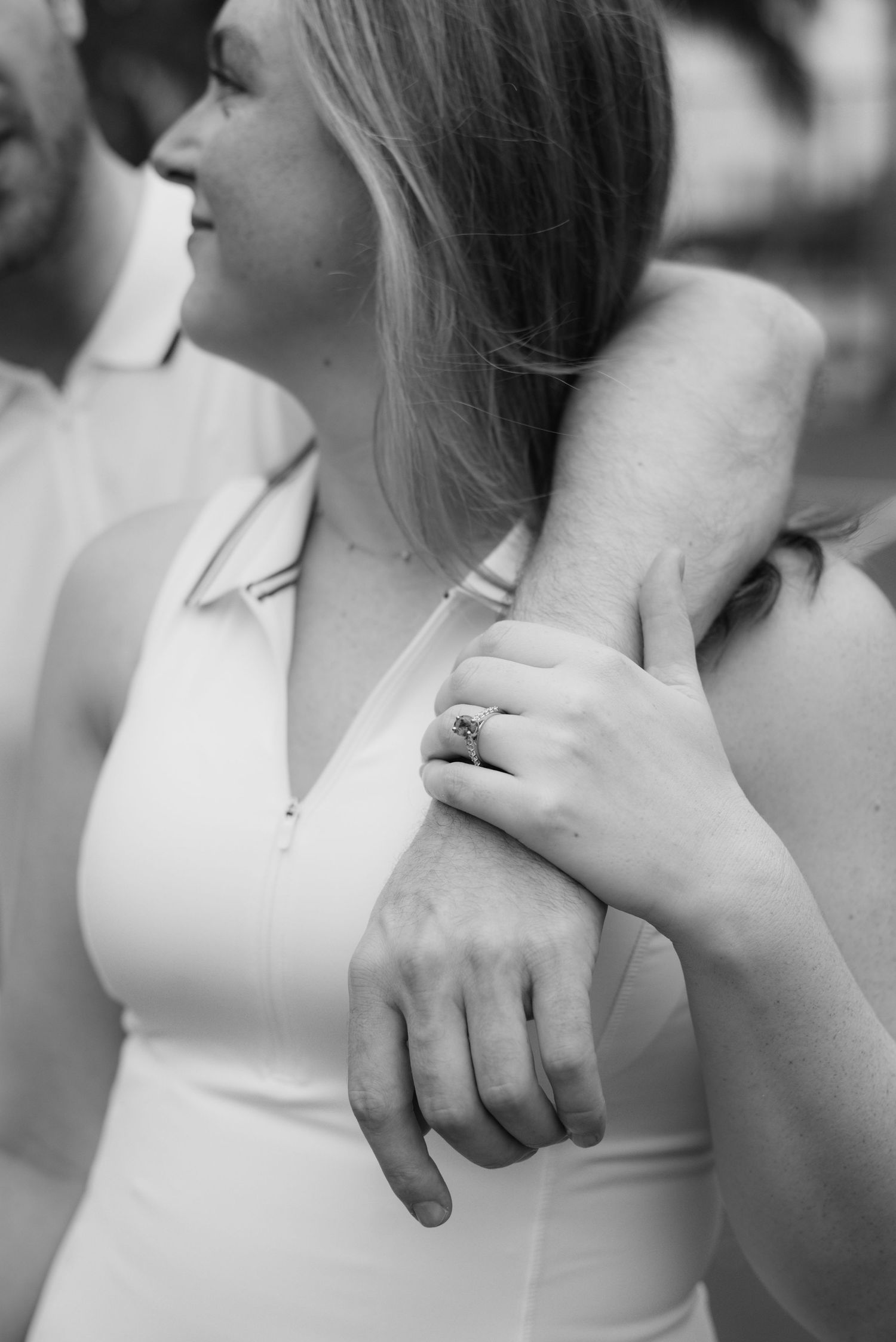Close-up series of a couple embracing in white tennis outfits on a sunny day.