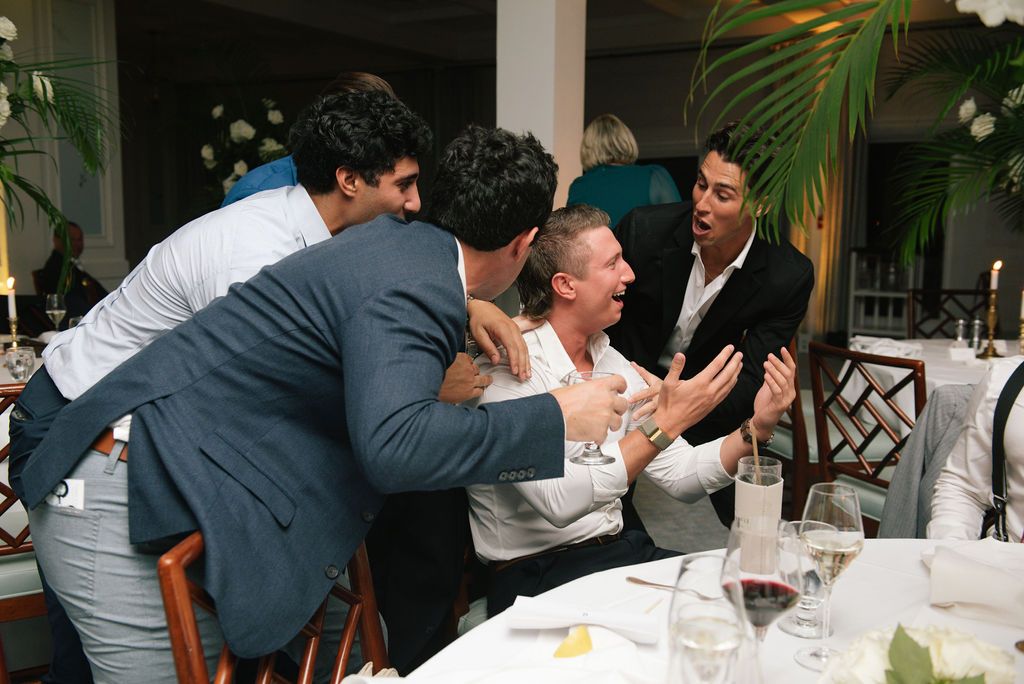 Wedding reception guests laugh and enjoy themselves during the celebration.