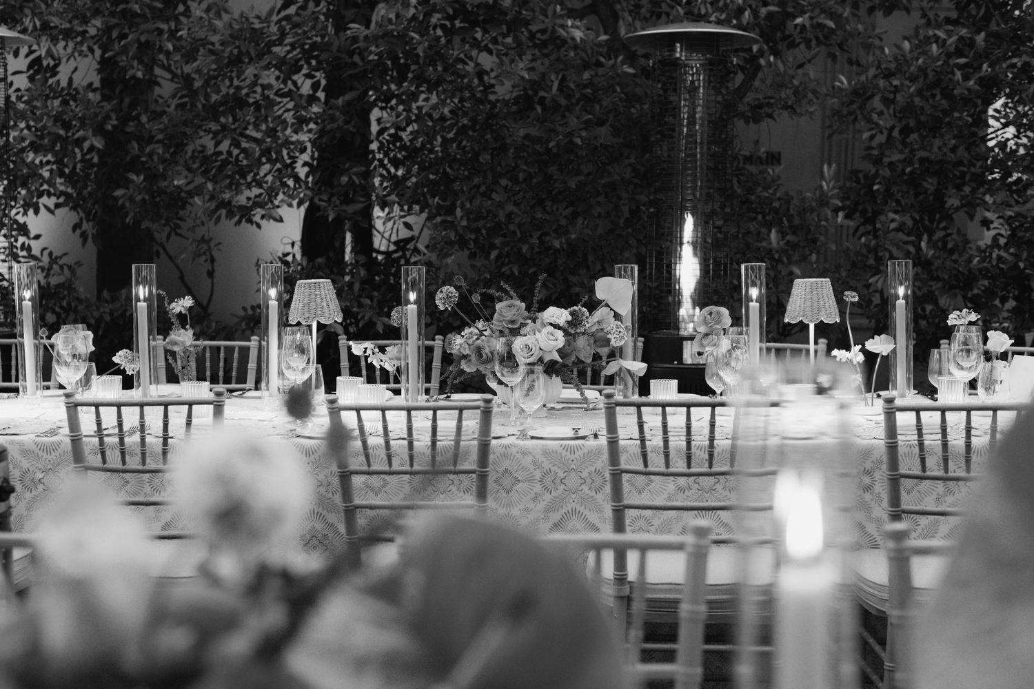 Outdoor wedding reception setup with elegant chiavari chairs arranged in rows at dusk.