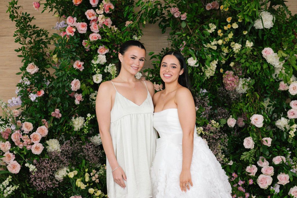 Wedding party photos captured against a romantic rose-covered garden wall.