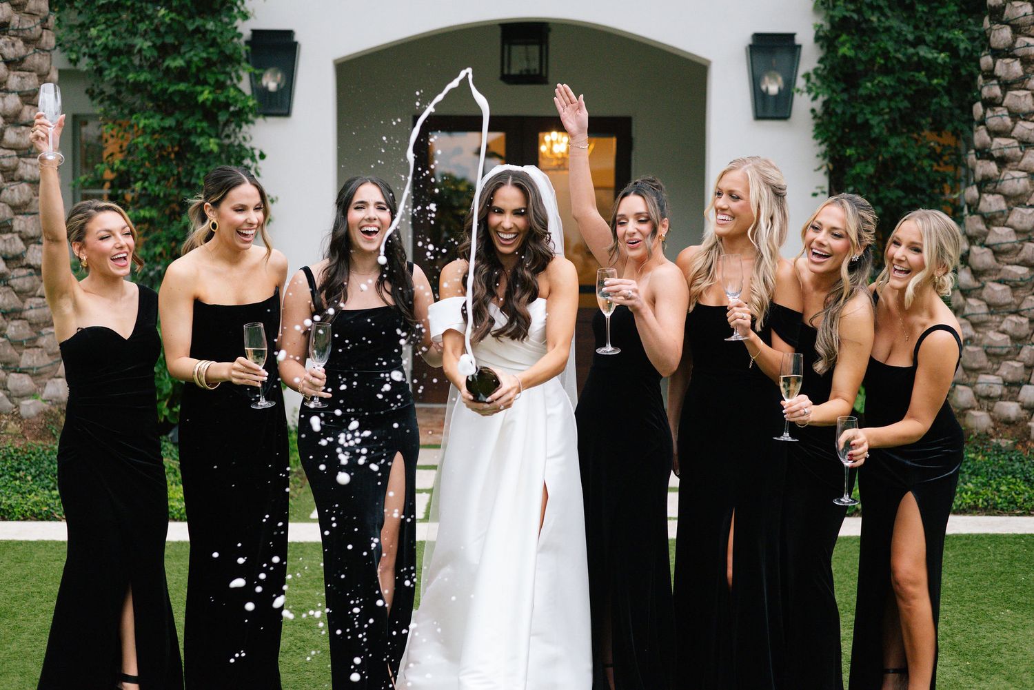 Wedding party celebrates joyfully outdoors with confetti.
