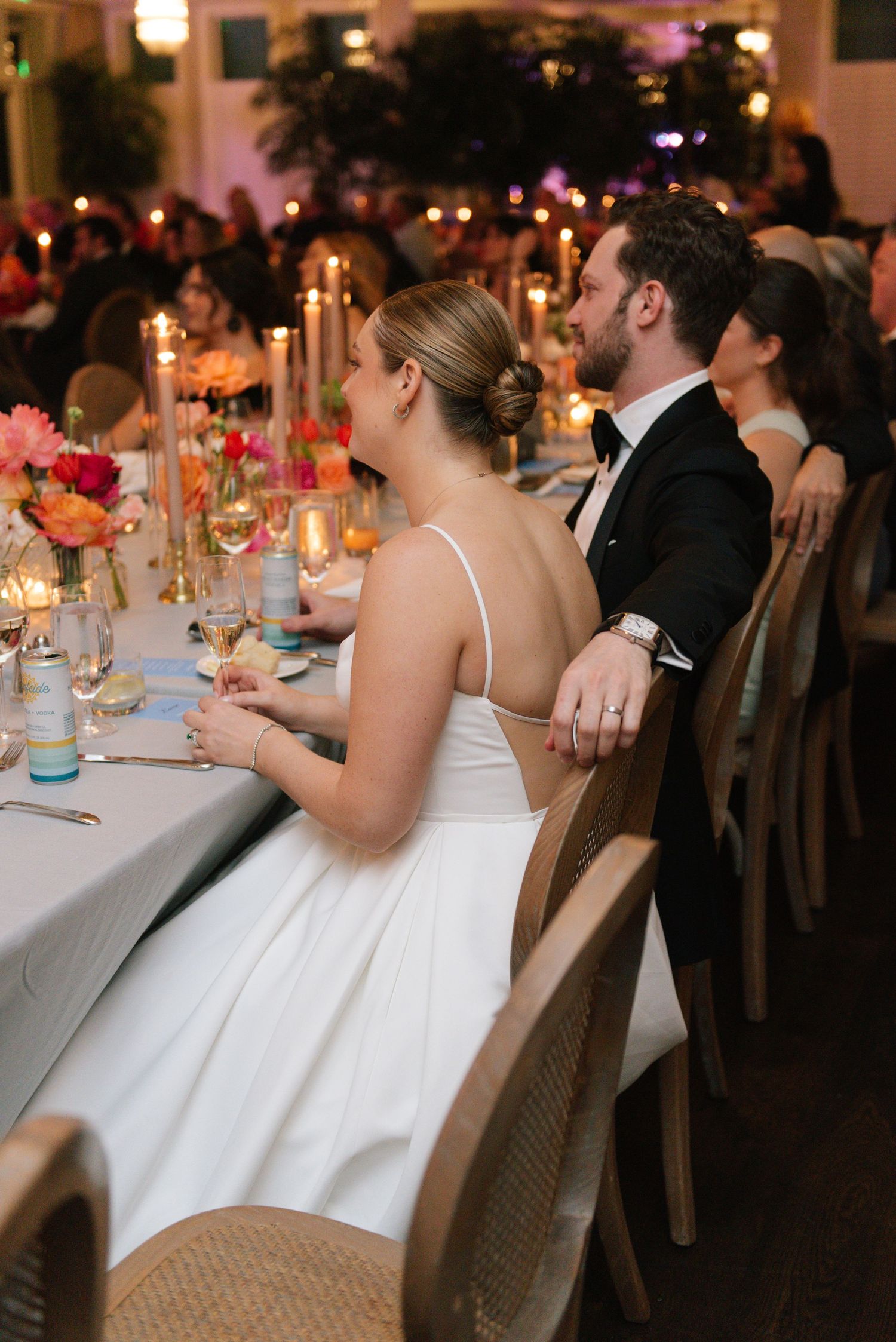 Wedding reception table setting with guests seated at an elegantly decorated dinner table.