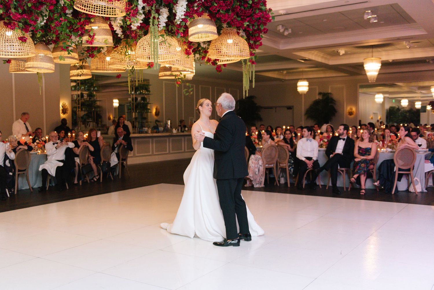 Wedding reception first dance under dramatic floral decorations.