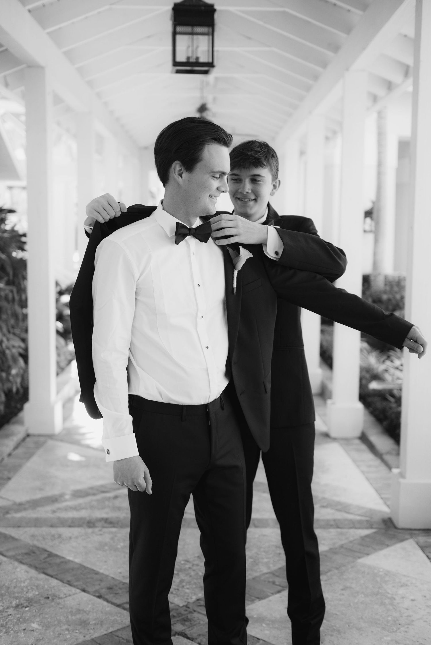 Formal wedding preparations in a bright white columned walkway.