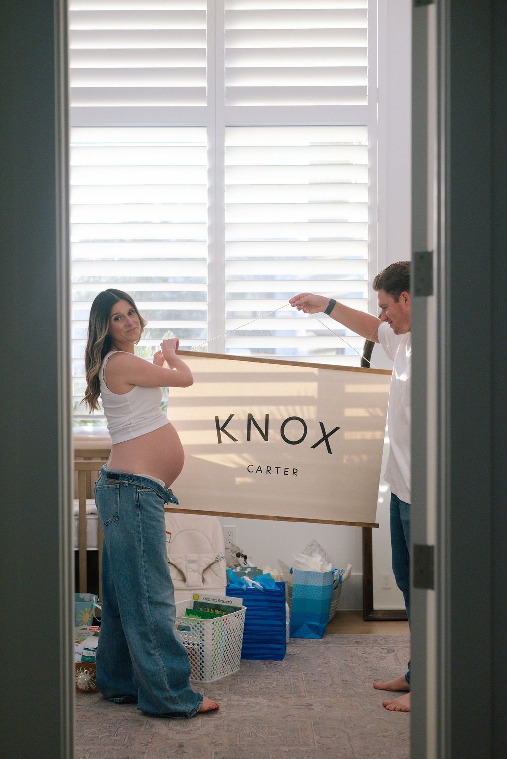 Moving boxes labeled Knox being unpacked in a bright room with window shutters.