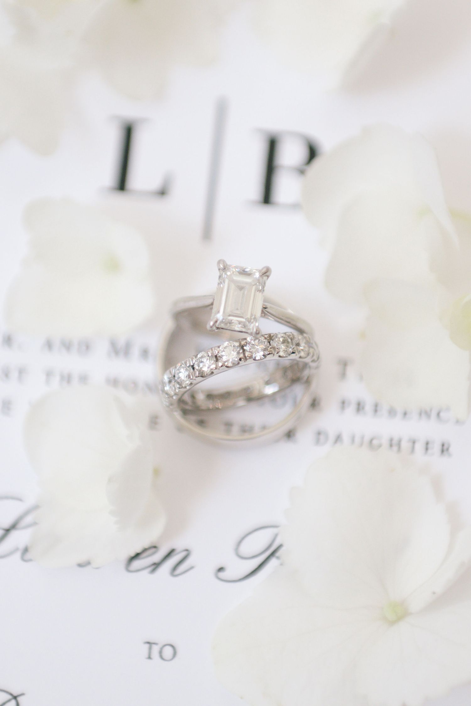 Elegant diamond engagement rings displayed on white paper with delicate text and floral accents.