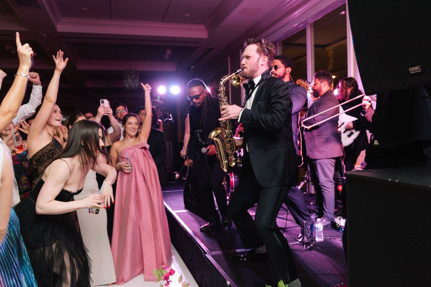 Live band performing at wedding reception with dancing crowd.