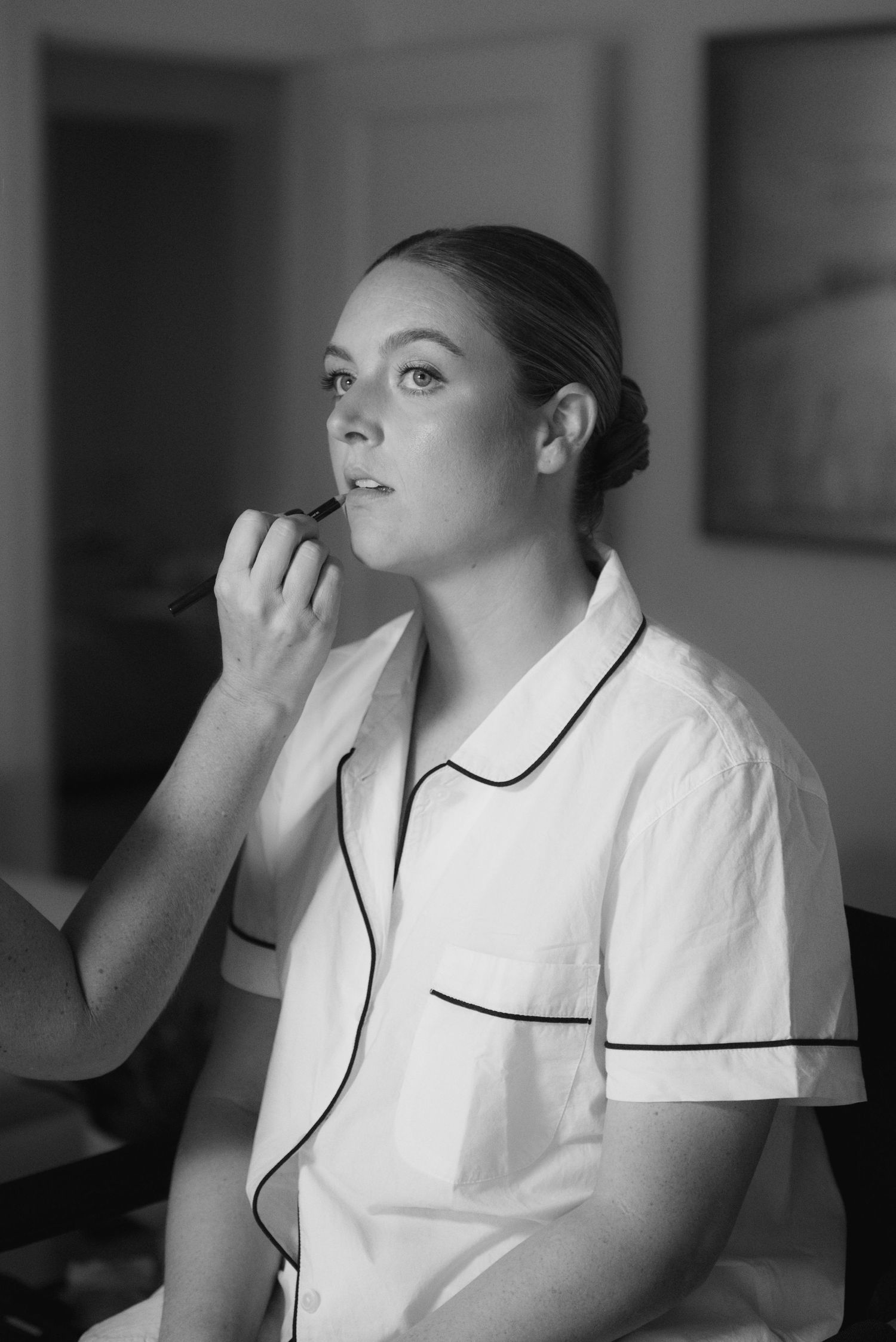 Black and white series showing someone in a white medical uniform with black piping drinking from a cup.