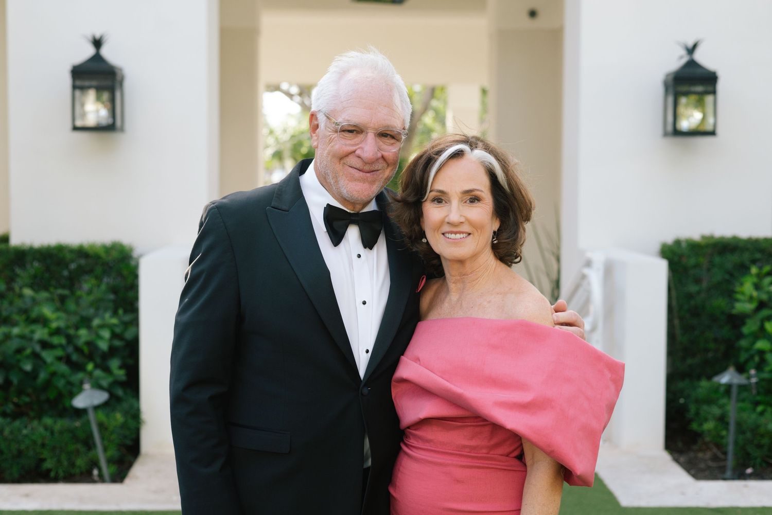 Wedding guests in formal attire gather for outdoor celebration.