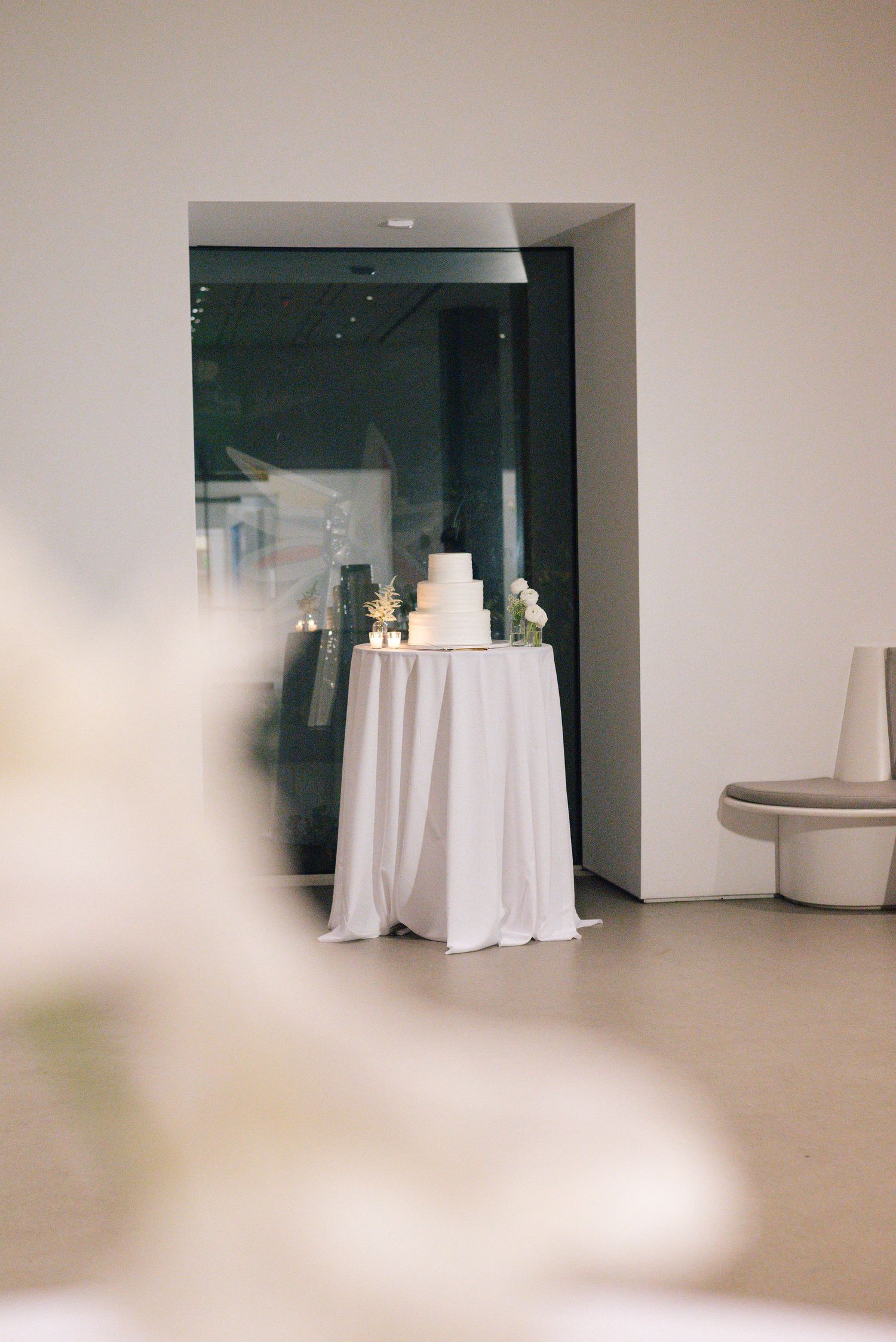 Modern minimalist event space with white round tables and neutral walls.