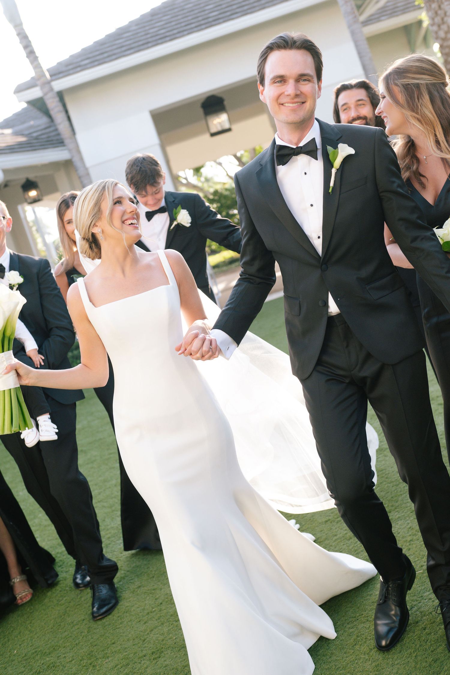 Candid dancing moments between newlyweds on green lawn.