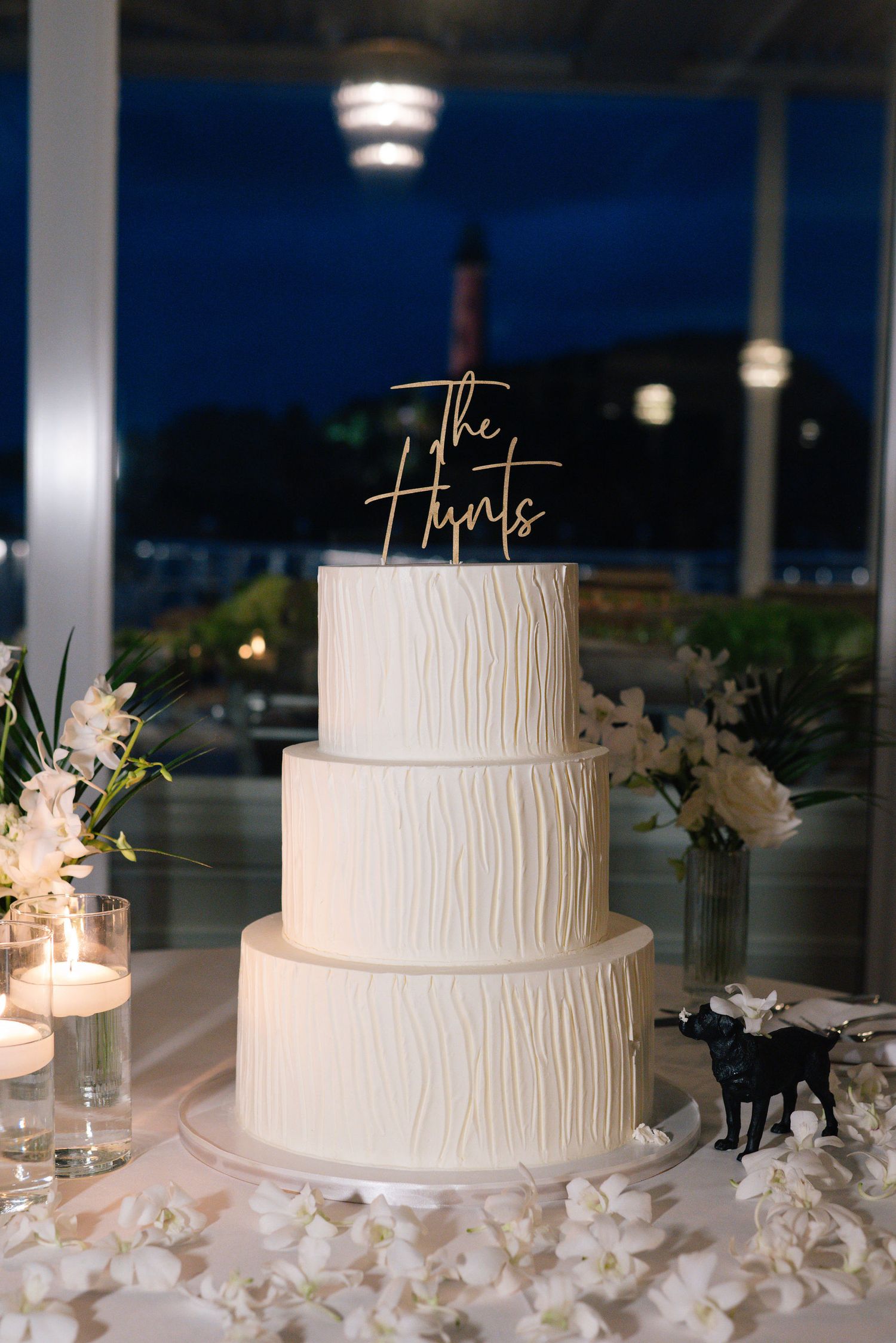 Minimalist white textured wedding cake displayed with floral decorations.